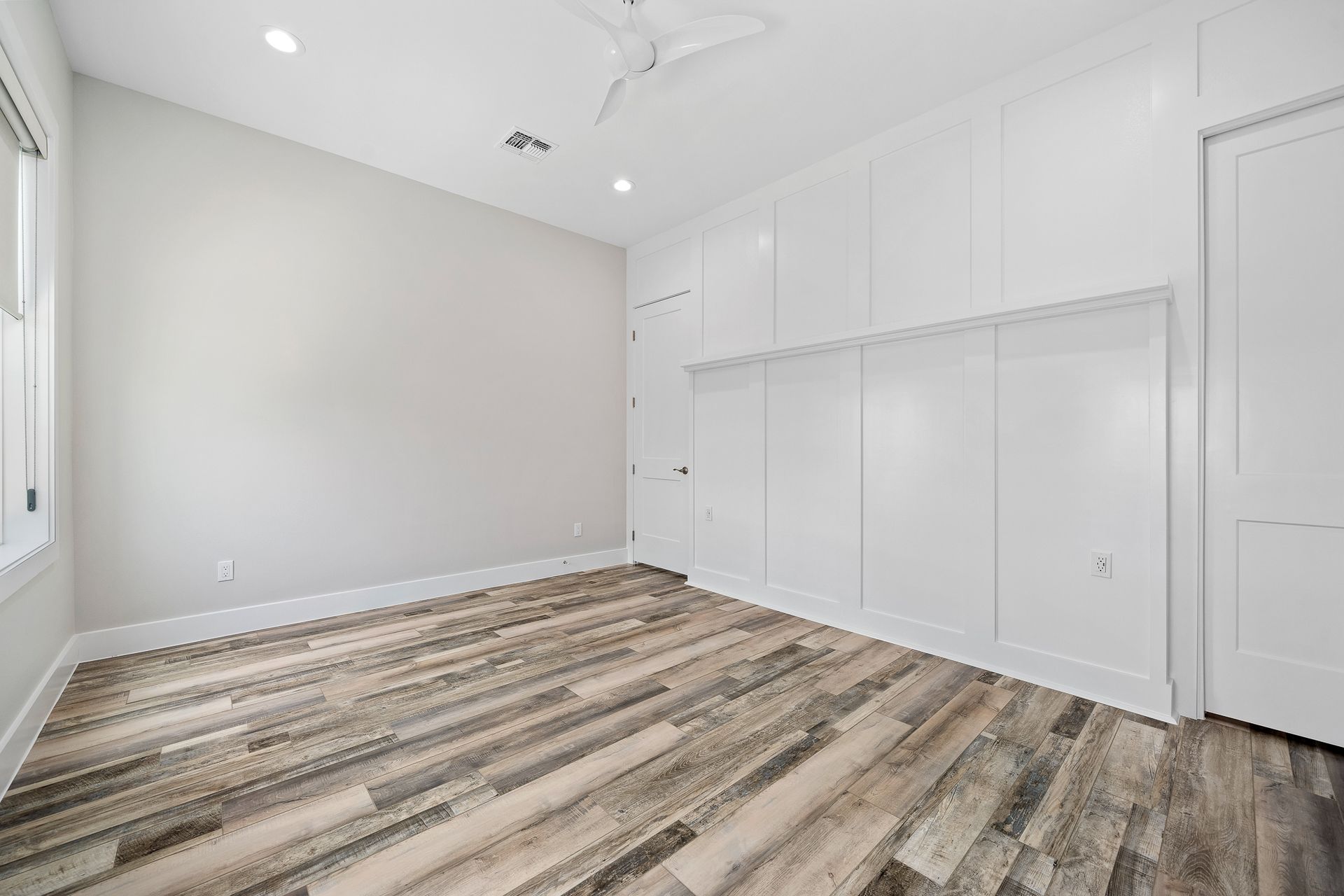 An empty room with a wooden floor and white walls.