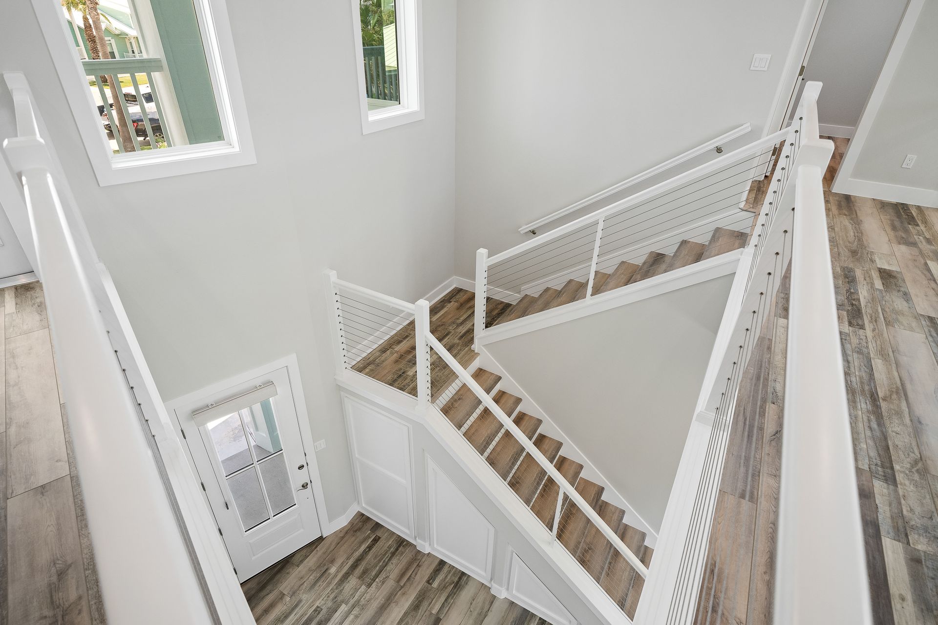 A view of a staircase from the second floor of a house.