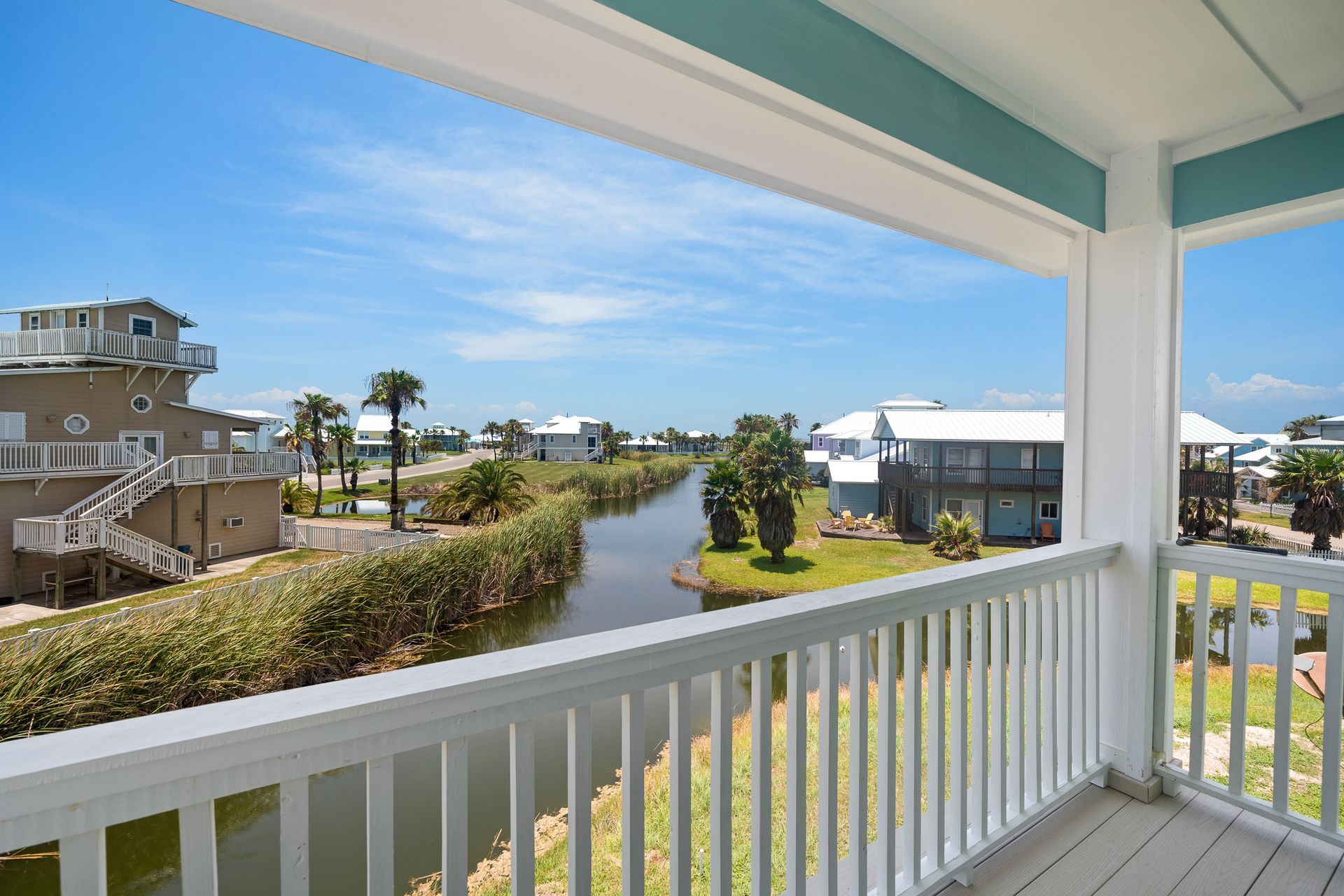 A balcony with a view of a river and houses