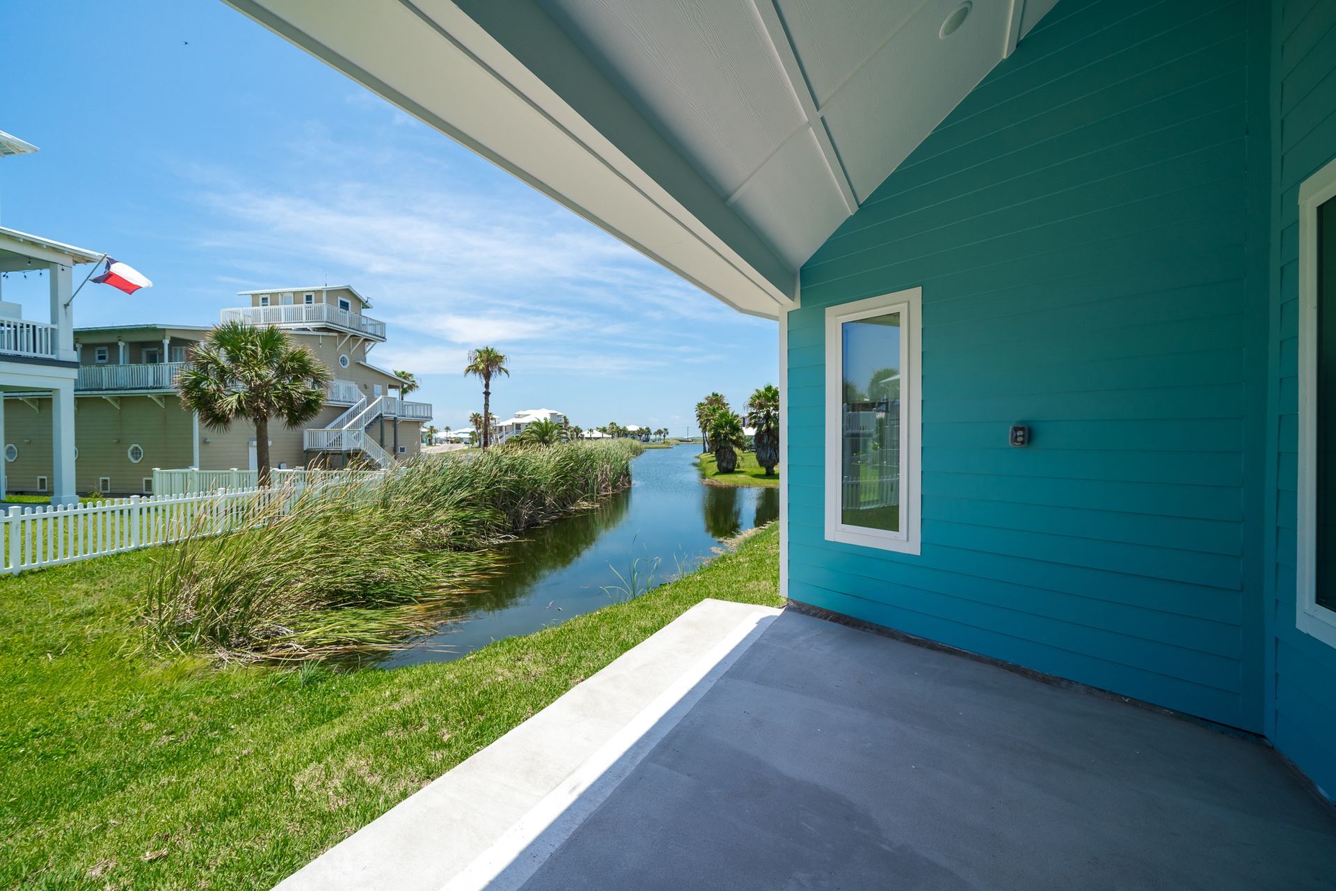 A blue house with a porch overlooking a body of water