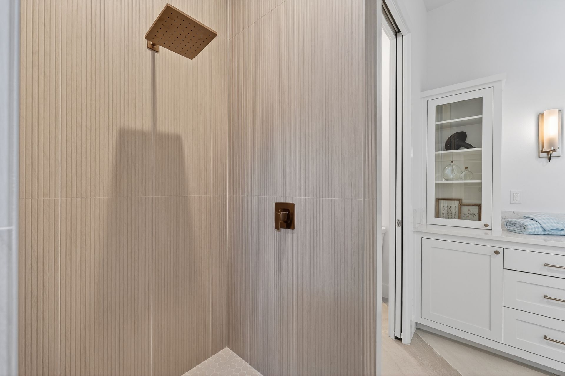 Modern bathroom with striped wall, wooden wall fixture, and white vanity in the background
