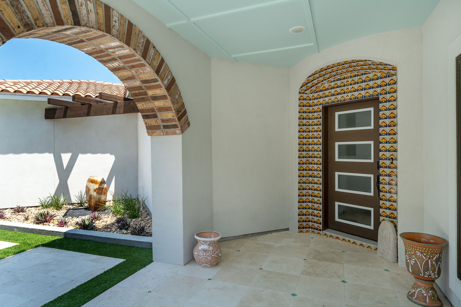 A house with a brick archway and a brown door