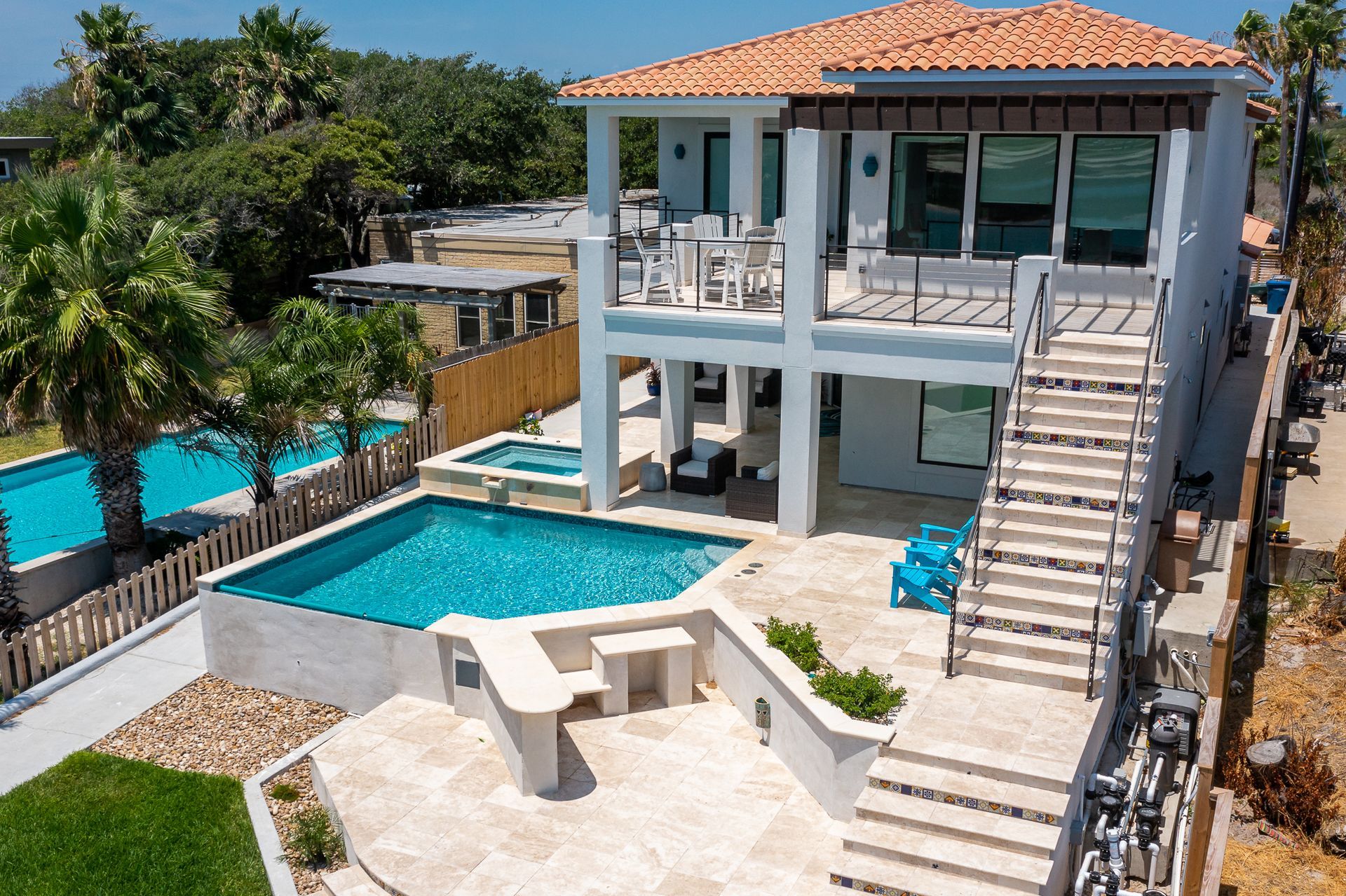 An aerial view of a house with a large swimming pool