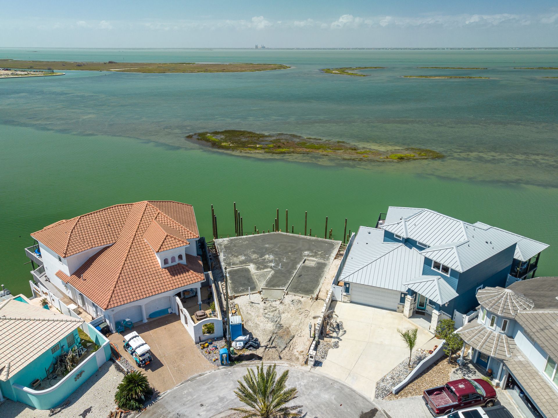 An aerial view of a house in the middle of a body of water
