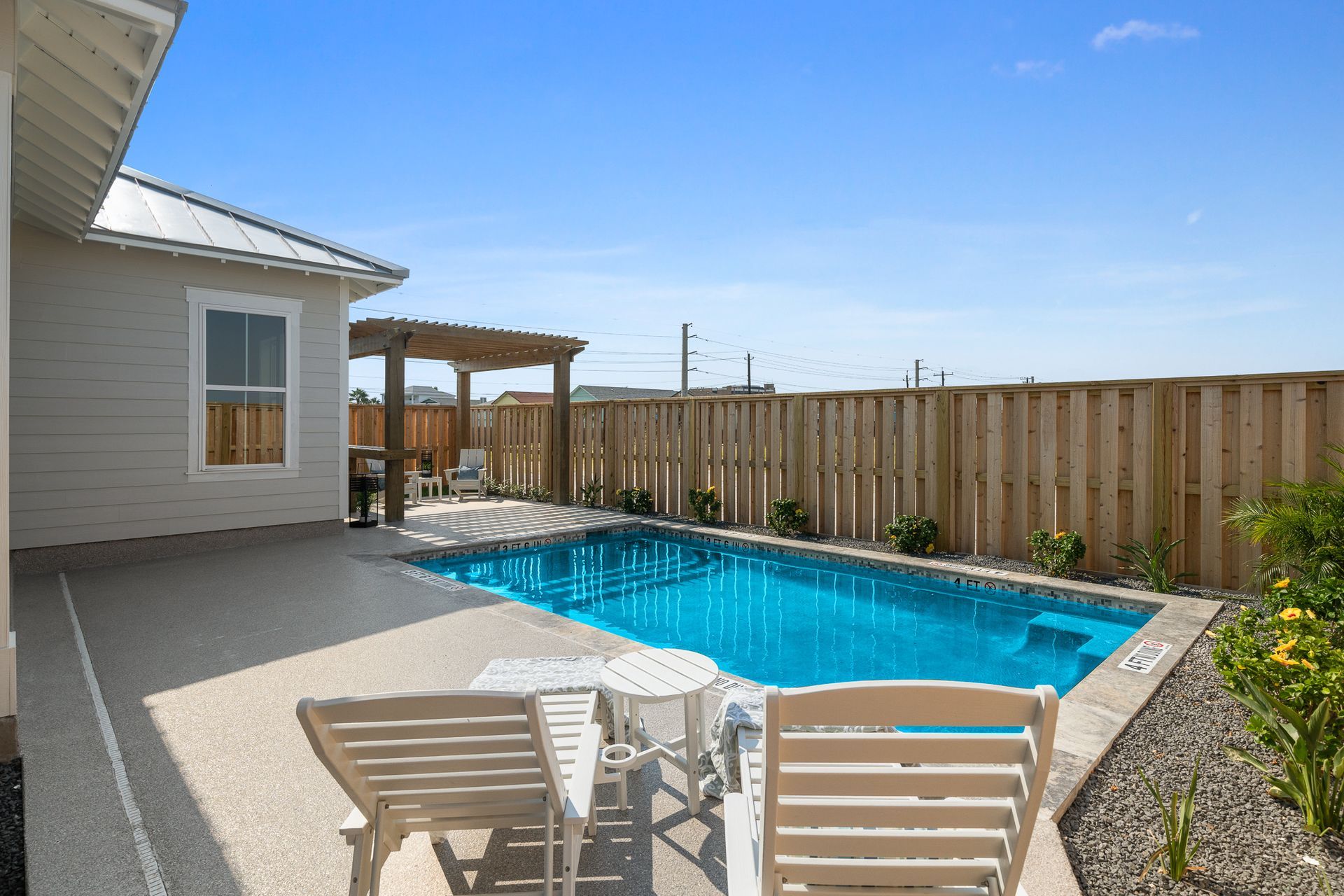 There is a small swimming pool in the backyard of a house.