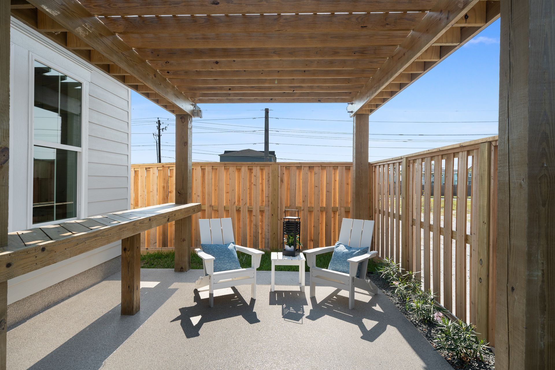 A patio with chairs and a table under a pergola