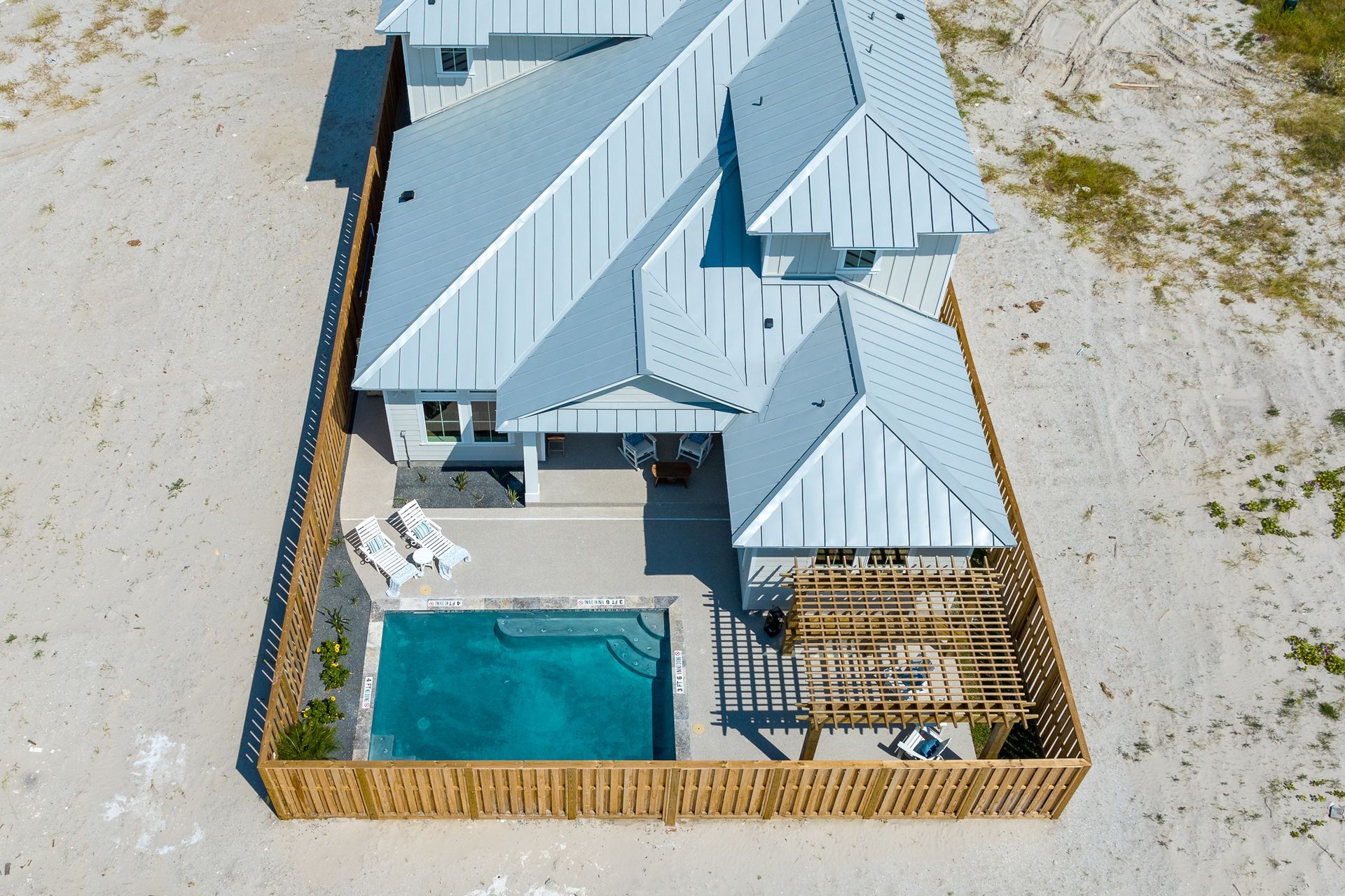 An aerial view of a house with a pool in the backyard