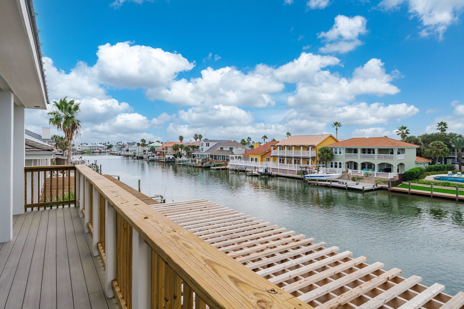 A balcony overlooking a body of water with houses in the background.