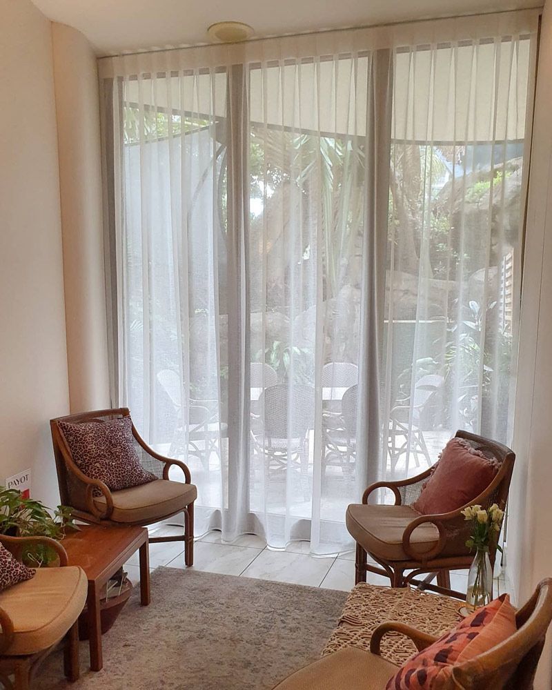 A Living Room With Chairs, a Table, and a Large Window — Artizen Curtains in Mooloolaba, QLD