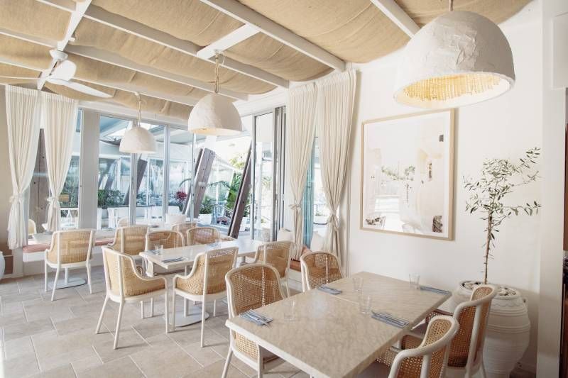 A Restaurant With Tables and Chairs and a Ceiling Fan — Artizen Curtains in Mooloolaba, QLD
