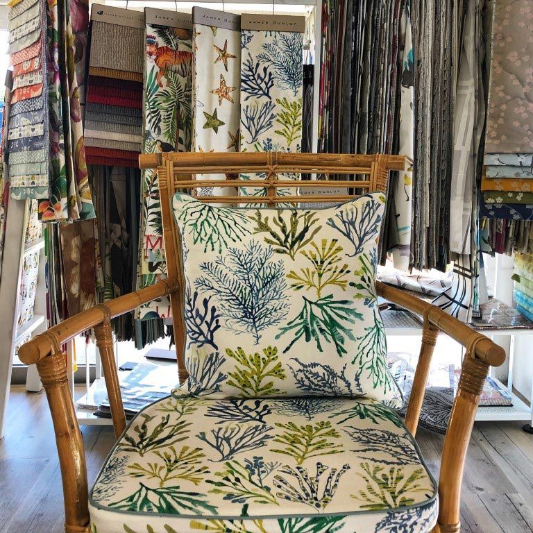 A Wicker Chair With a Colorful Pillow on It — Artizen Curtains in Mooloolaba, QLD