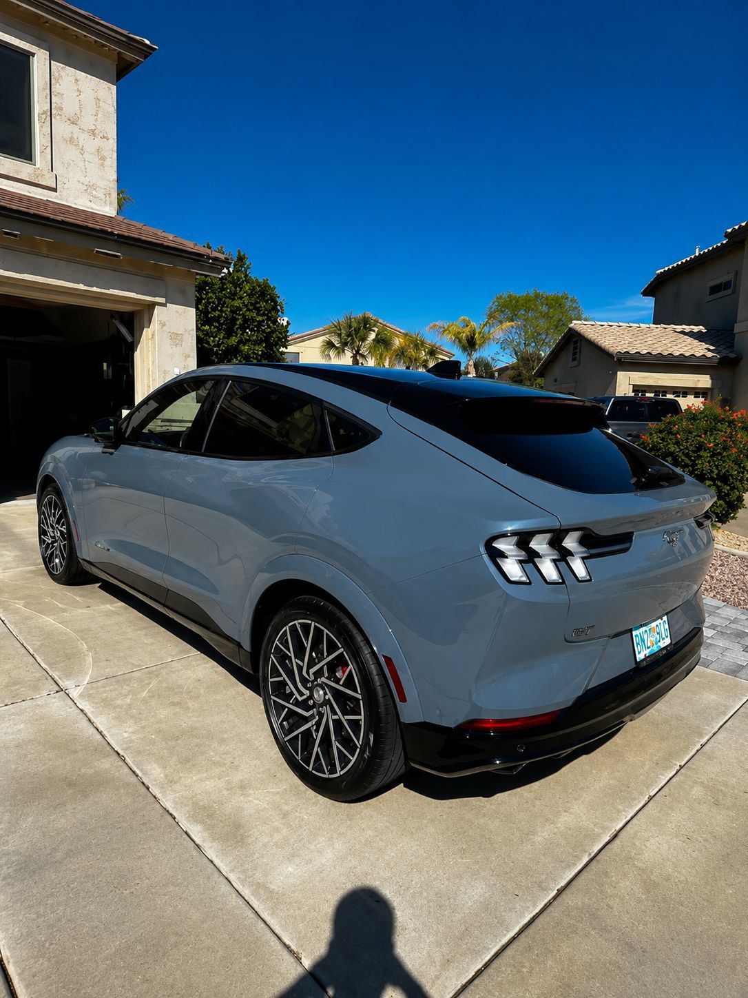 Silver sports SUV parked in a driveway outside a house on a sunny day.