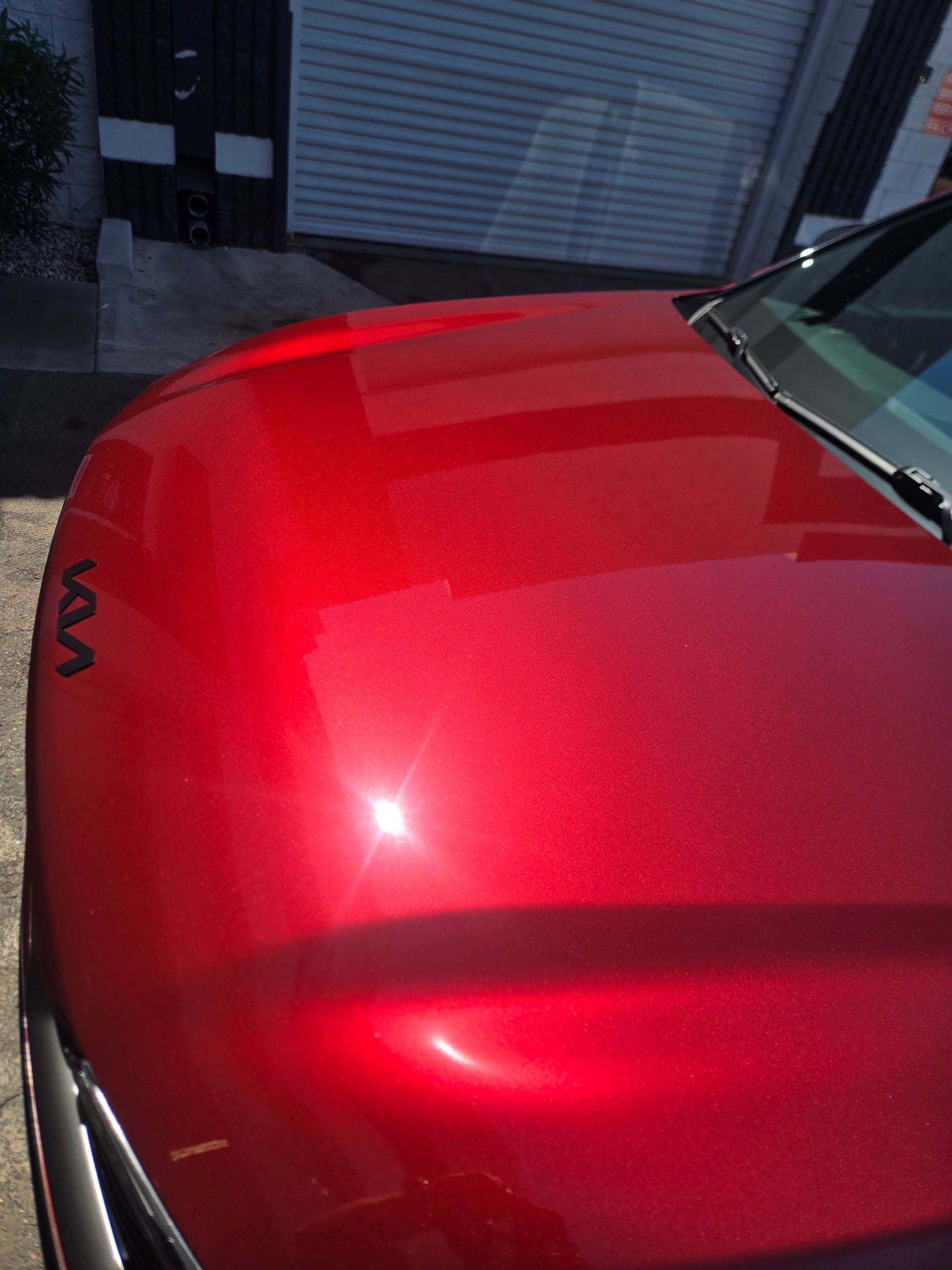 Close-up of metallic red vehicle paint showcasing ceramic coating gloss and smooth finish