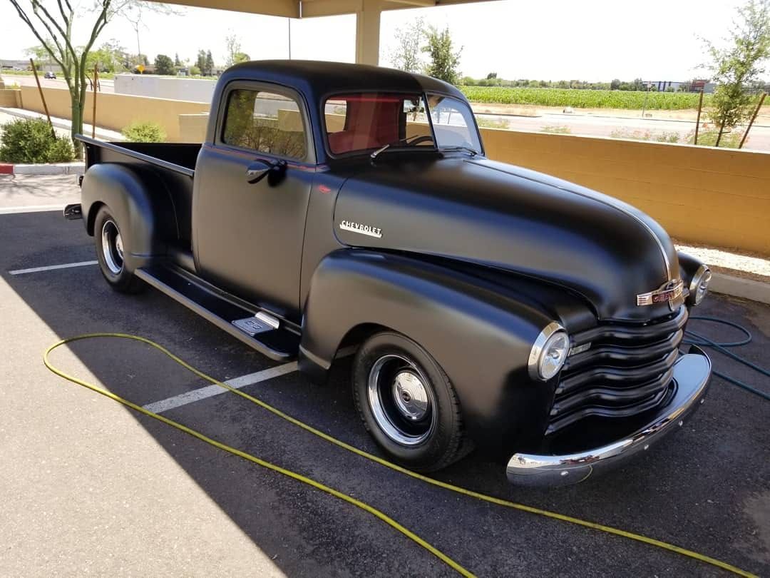 Restored black Chevrolet pickup truck with polished paint after professional detailing