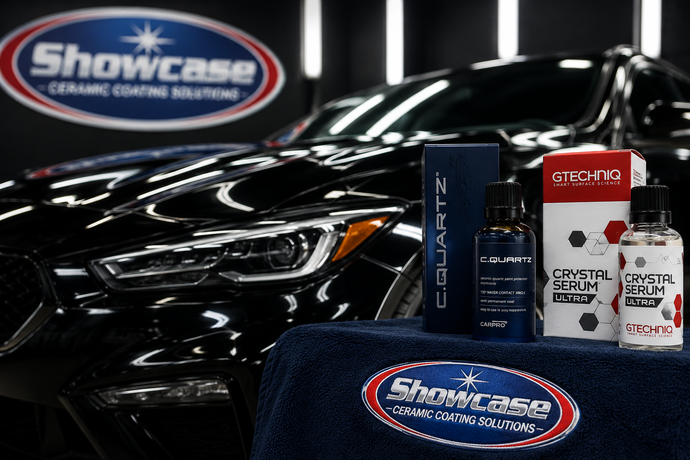 Black car with detailing products and Showcase logos on a display table and wall