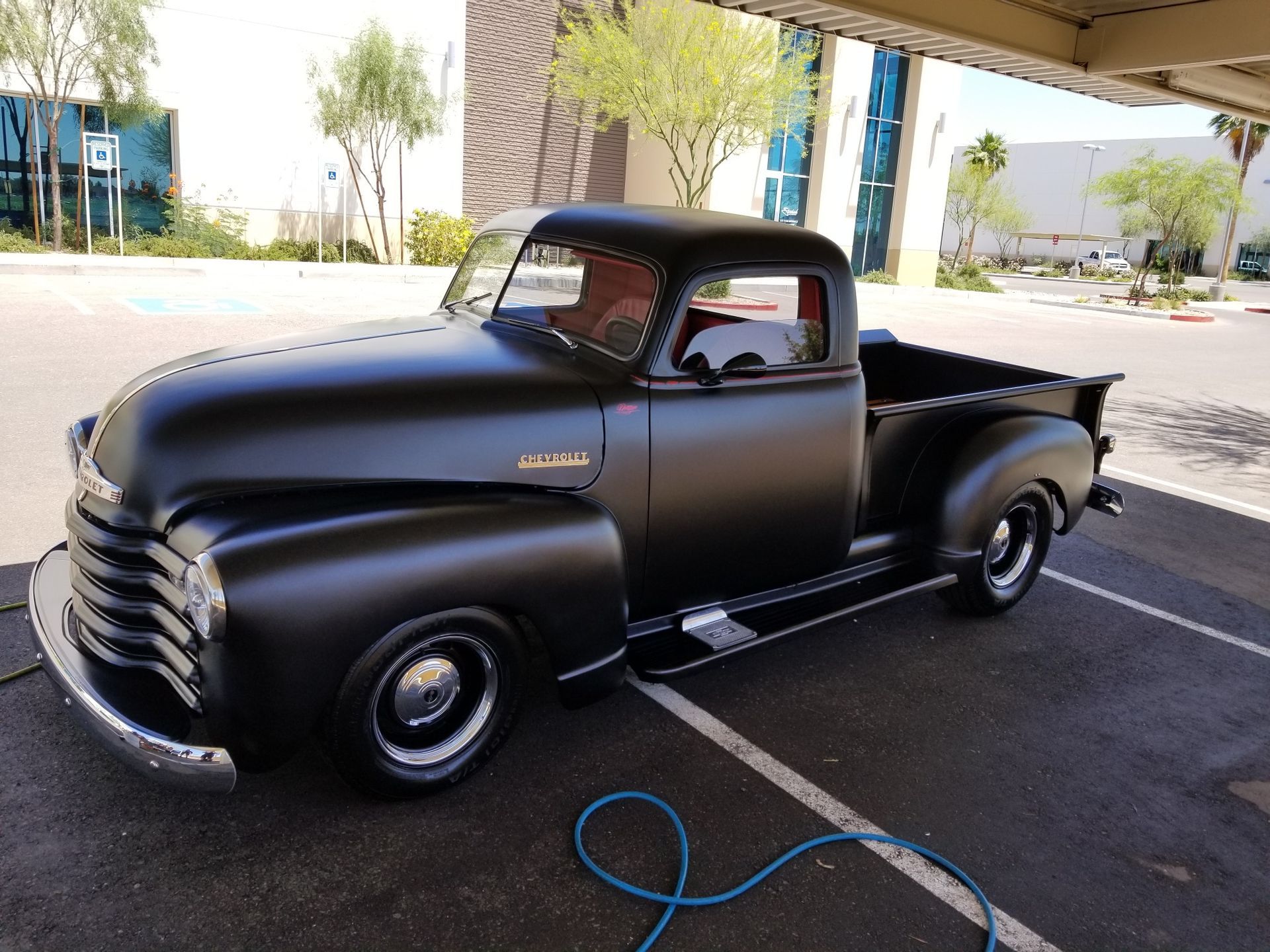 Classic Chevrolet pickup with glossy black finish after paint polishing