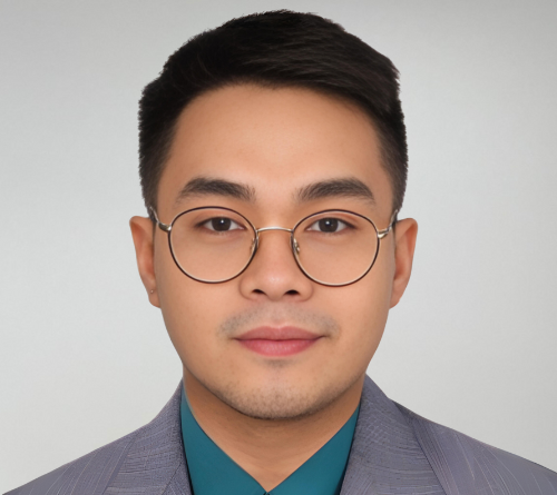 A man wearing glasses and a suit looks at the camera