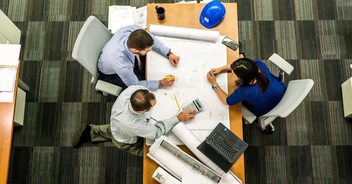 A group of people are sitting at desks in front of computers.
