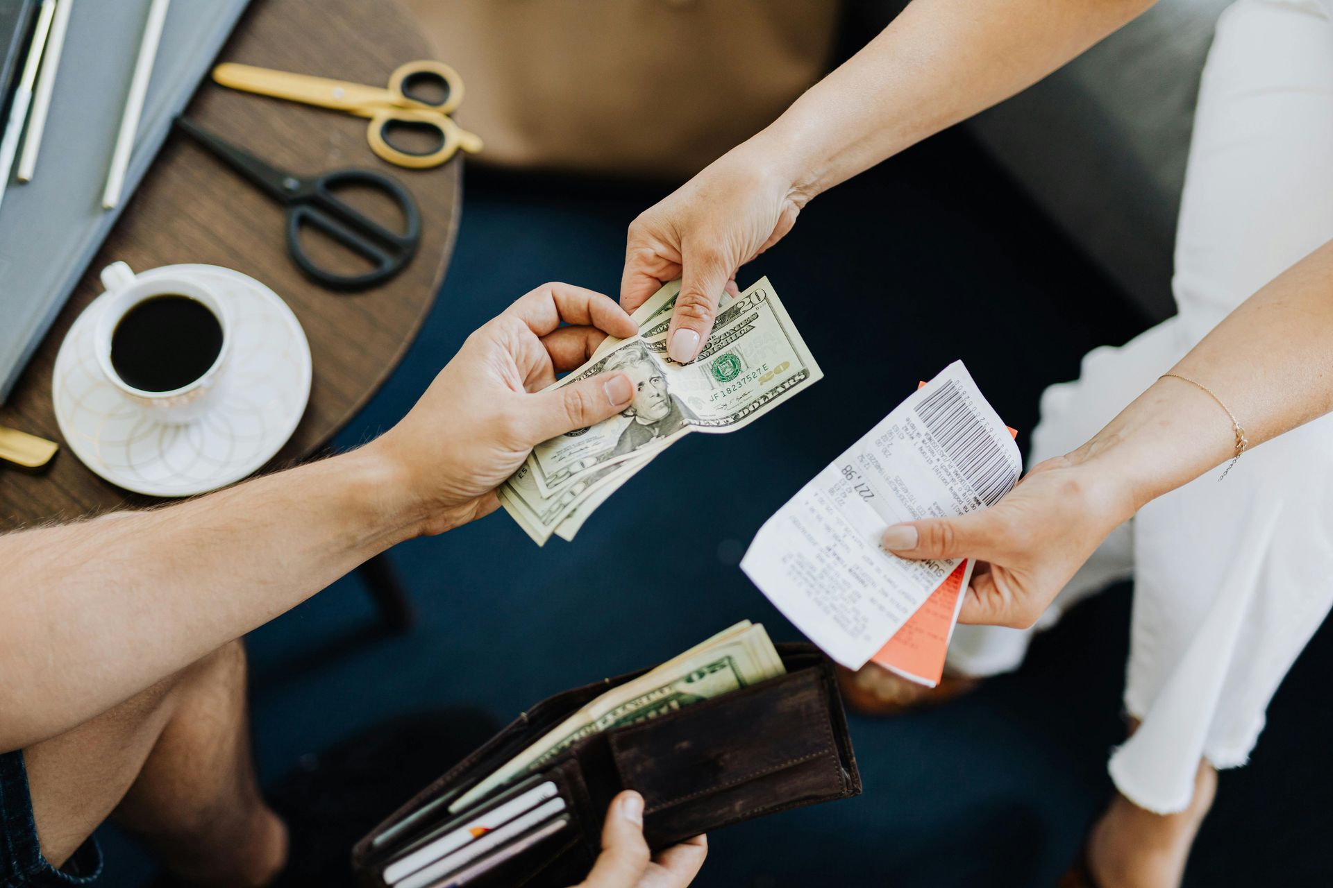A man is giving a woman money from his wallet.