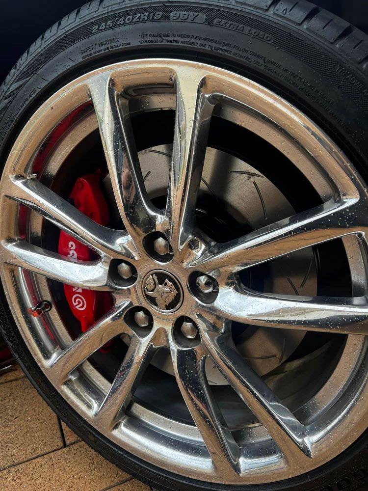 A Close Up Of A Car Wheel With Red Brake Calipers — MJ's Mobile Car Mechanic In Wollongong, NSW