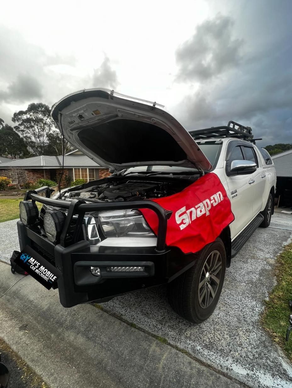 A White Truck With The Hood Up Is Parked In A Driveway — MJ's Mobile Car Mechanic In Picton, NSW