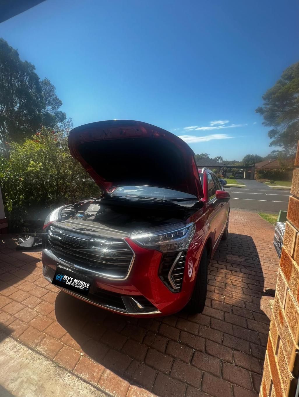 A Red Car With The Hood Up Is Parked In A Driveway — MJ's Mobile Car Mechanic In Fairy Meadow, NSW