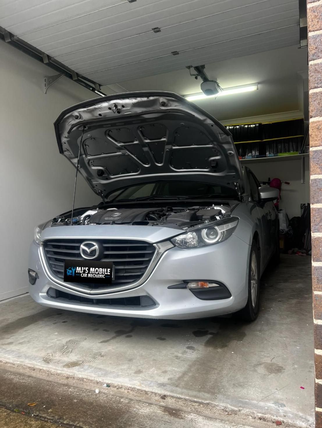 A Silver Car With The Hood Up Is Parked In A Garage — MJ's Mobile Car Mechanic In Bargo, NSW