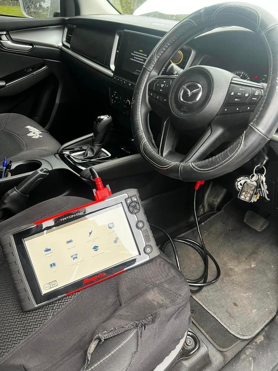 The Inside Of A Car With A Steering Wheel And A Tablet On The Seat — MJ's Mobile Car Mechanic In Bargo, NSW