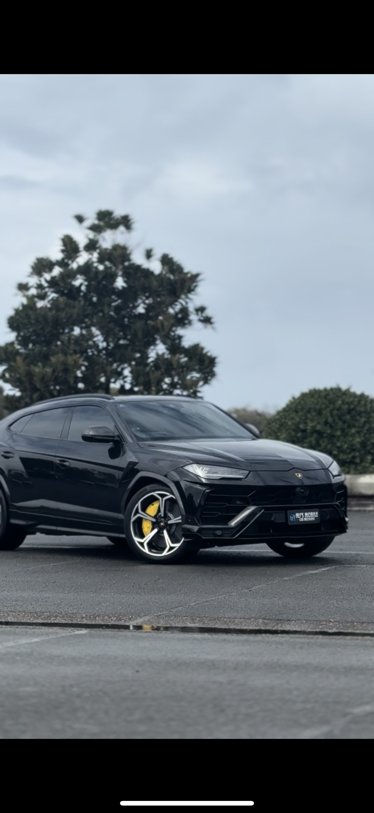 Black Lamborghini Urus SUV with gold wheels parked on asphalt  — MJ's Mobile Car Mechanic In Corrimal, NSW