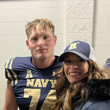 A man in a navy jersey is posing for a picture with a woman