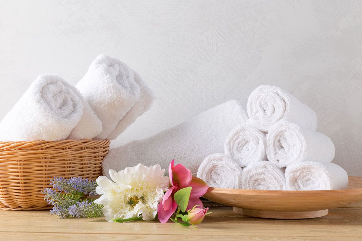 Una pila de toallas y flores sobre una mesa de madera.