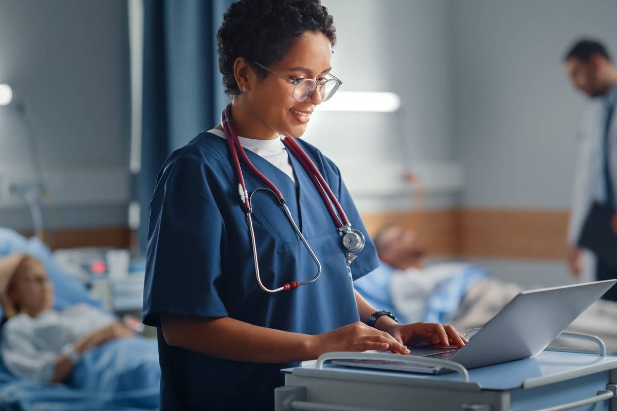 Female nurse practitioner typing on a laptop.