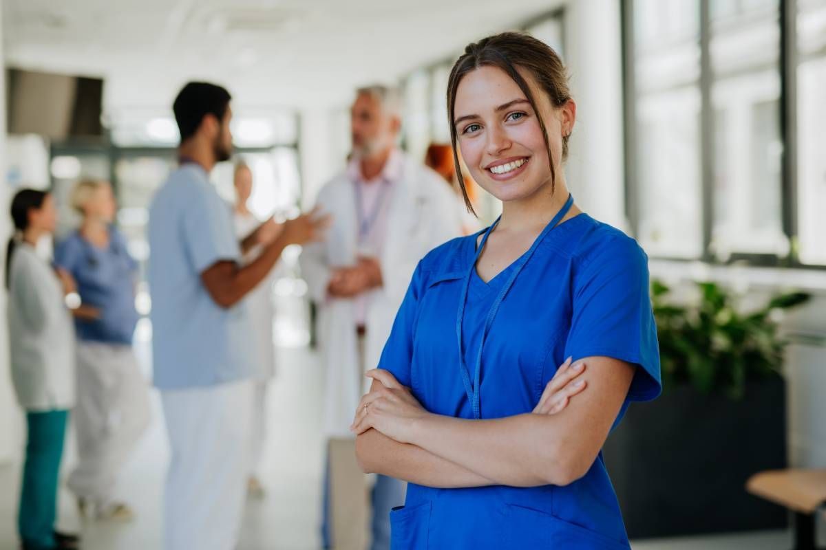 Female nurse practitioner smiling with arms crossed.