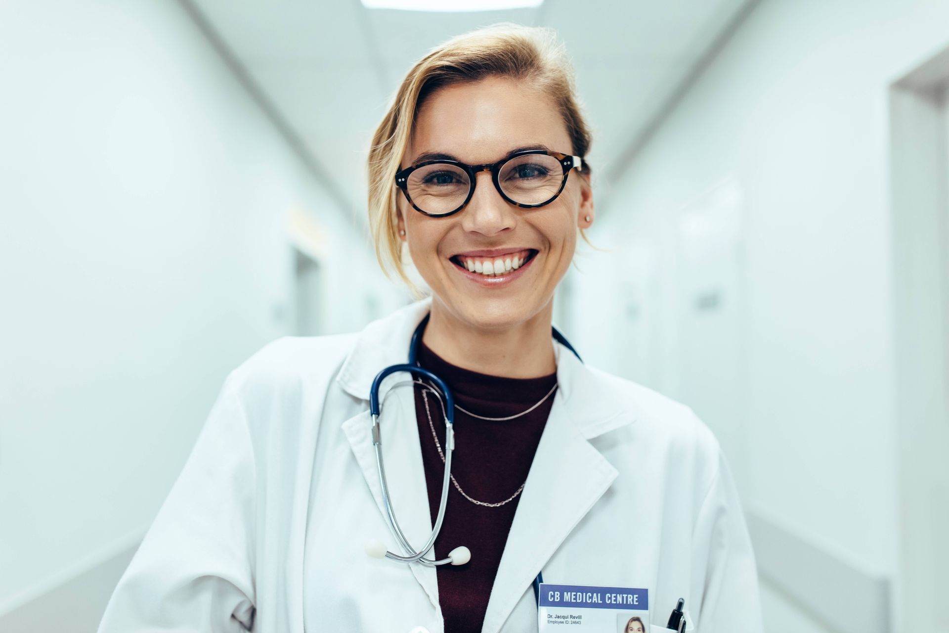 Female physician standing in a long corridor.
