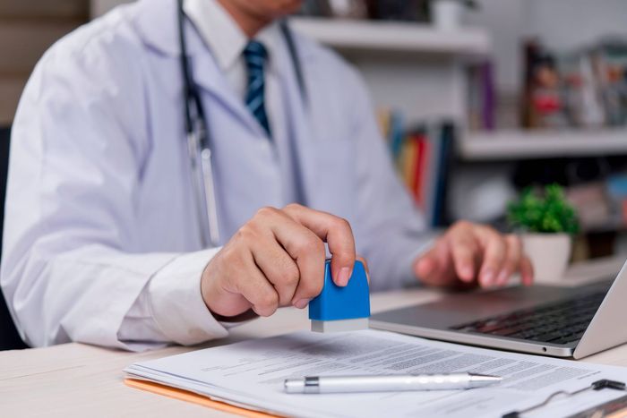 Medical professional putting a stamp of approval on a document