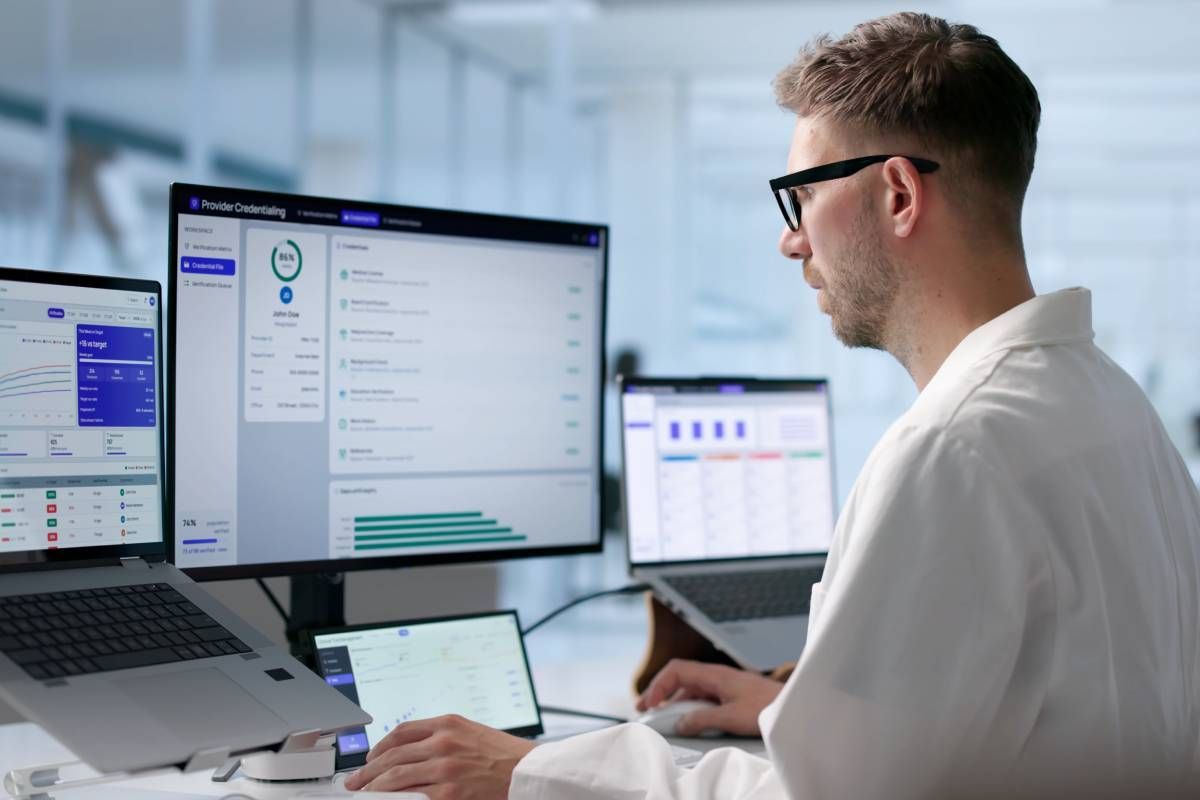 Young doctor looking at multiple computer screens at MDCredentialing
