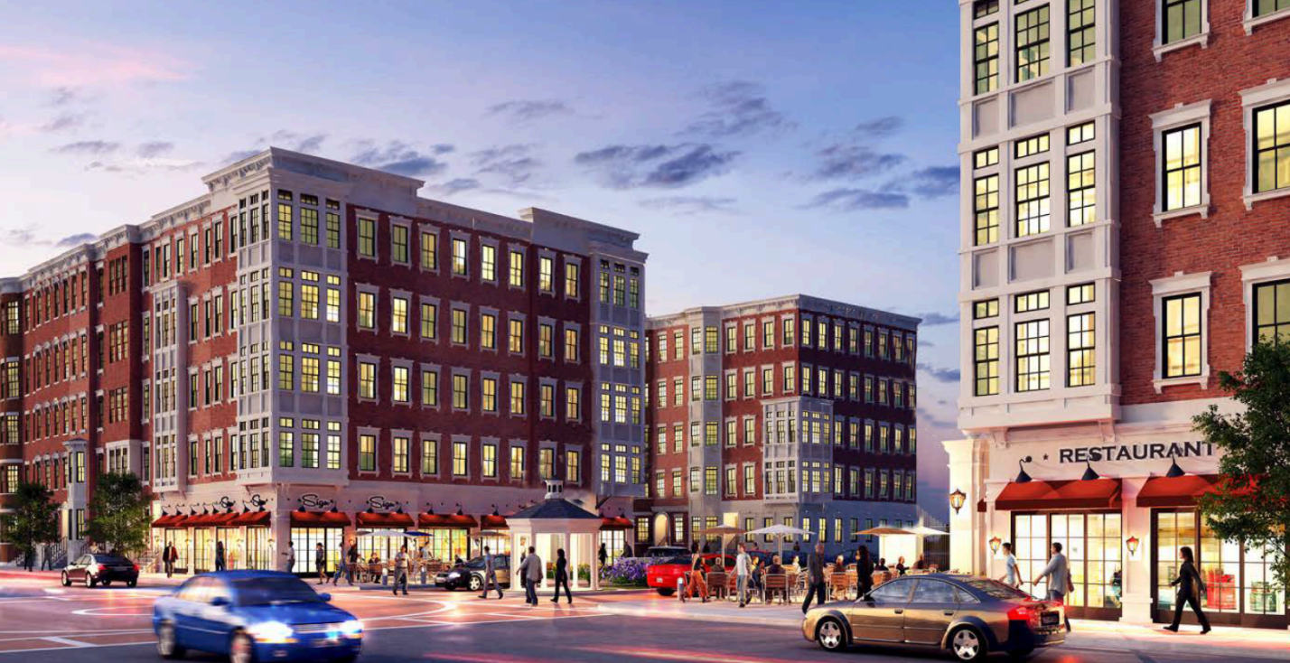 A blue car is driving down a street in front of a brick building.
