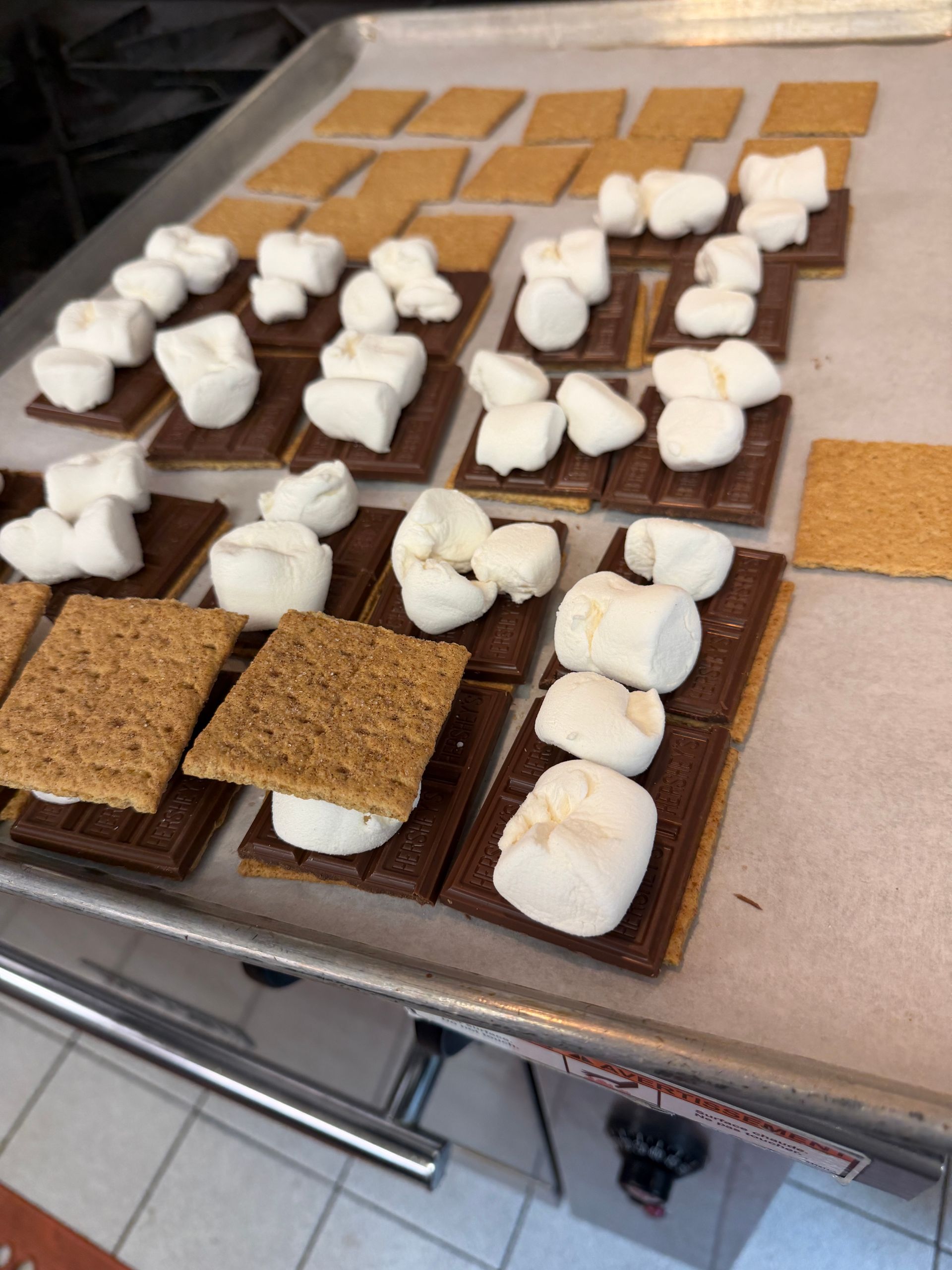 Tray of s'mores ingredients with chocolate, graham crackers, and marshmallows laid out for roasting