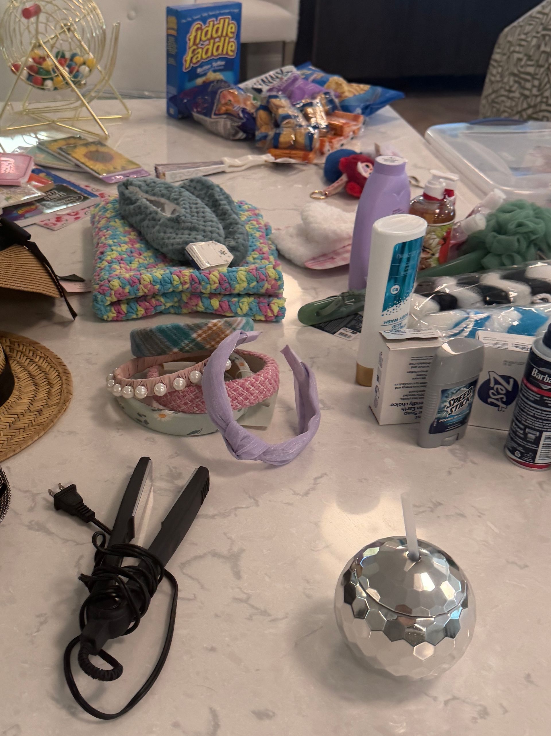 Assorted craft supplies and accessories spread across a white table, including headbands, clips, and bottles.