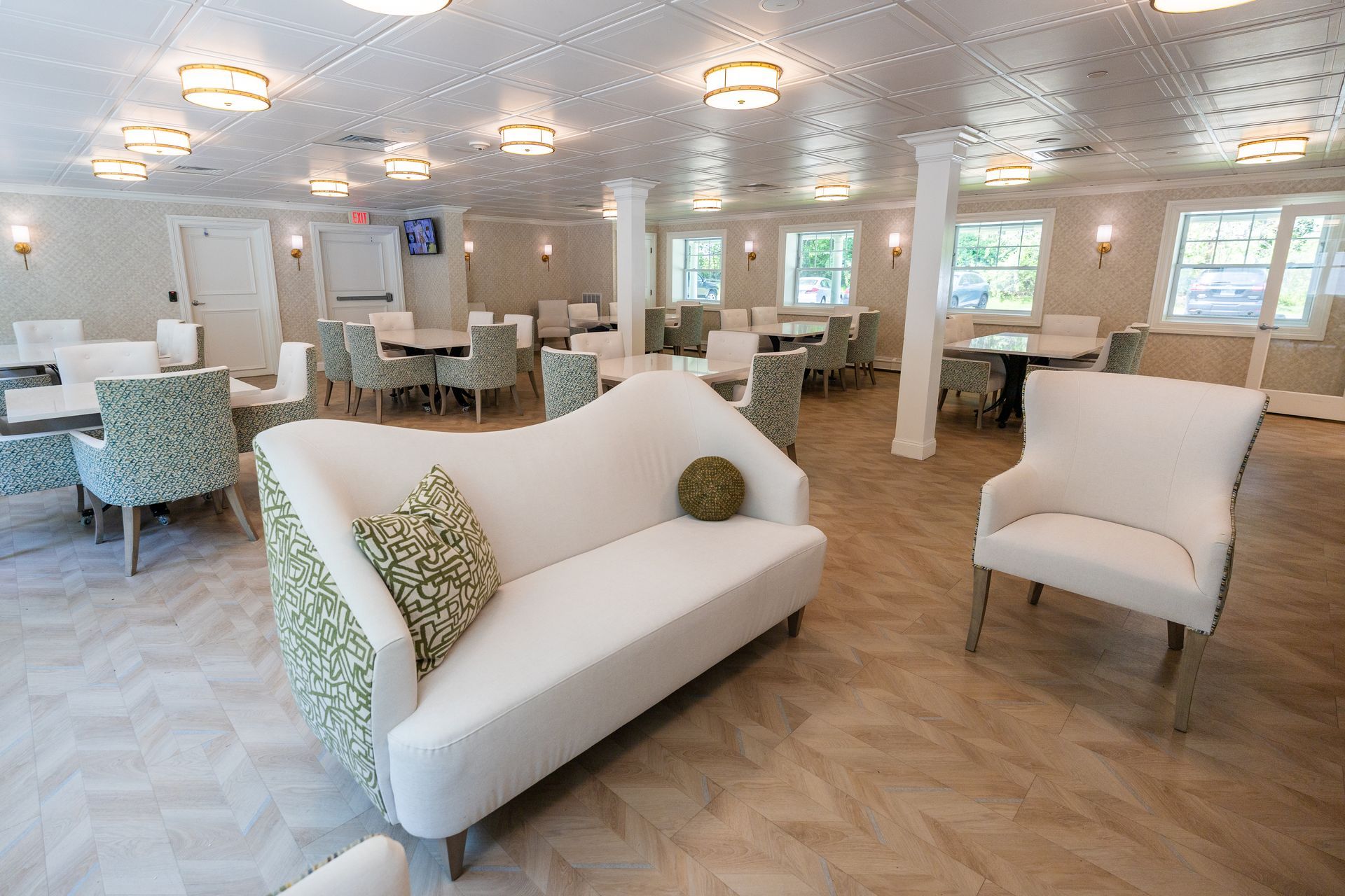Bright, modern lounge with white sofas, armchairs, and tables in a spacious seating area