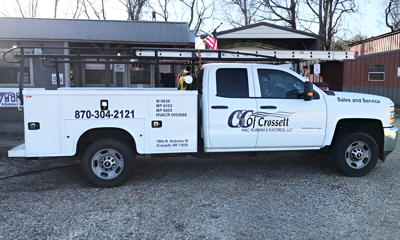 White service truck with company logo and phone number parked in front of a building