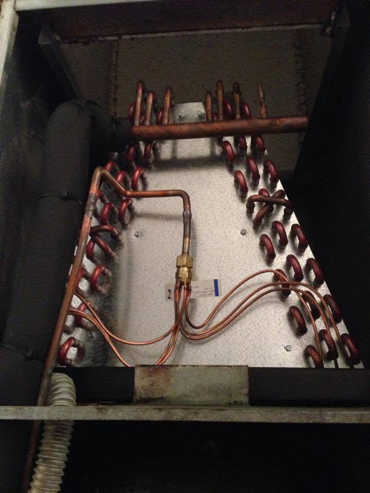 Copper coils and wires inside a metal electrical panel or mechanical unit.