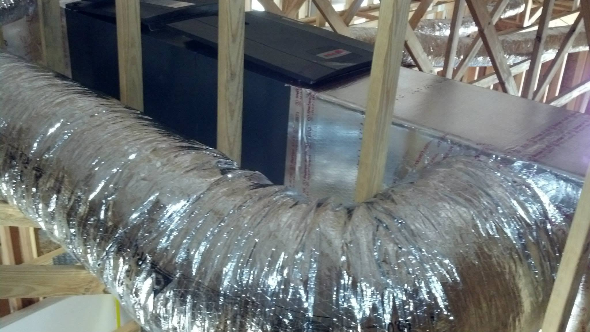 Flexible silver HVAC ducting installed in a building framework