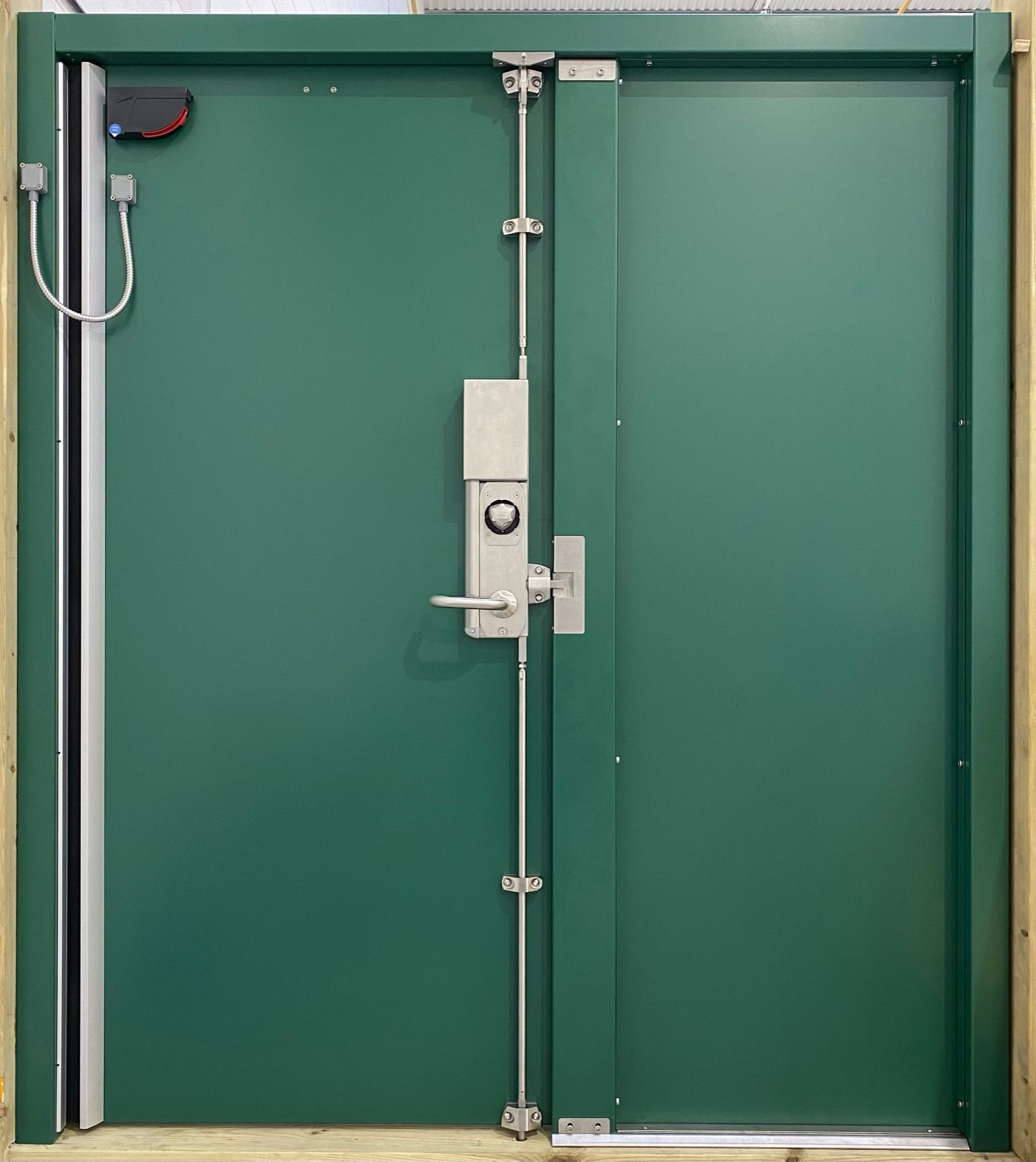 A green door with a stainless steel lock on it
