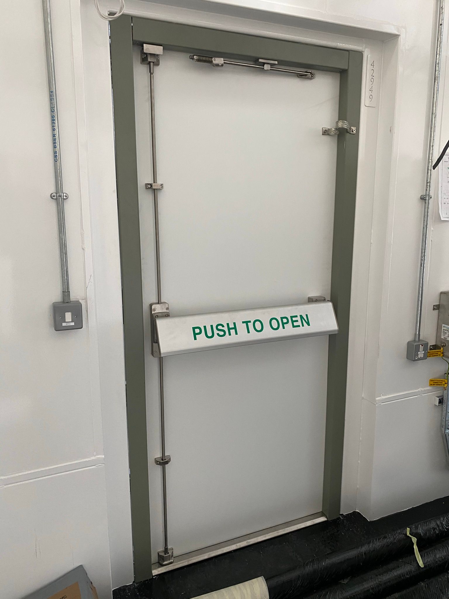A white door with a push to open sign on it.