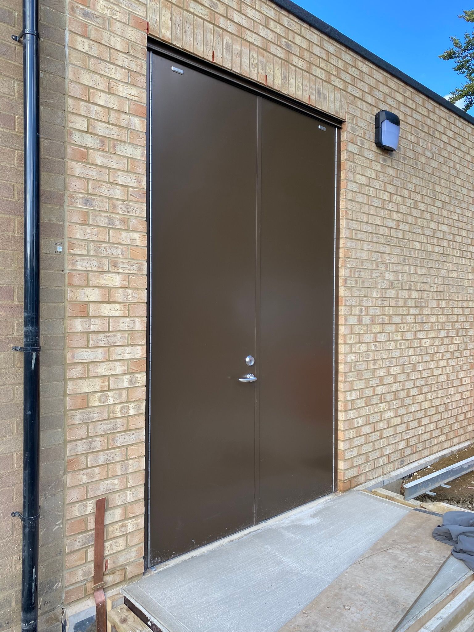 A black door with a yellow warning sign on it