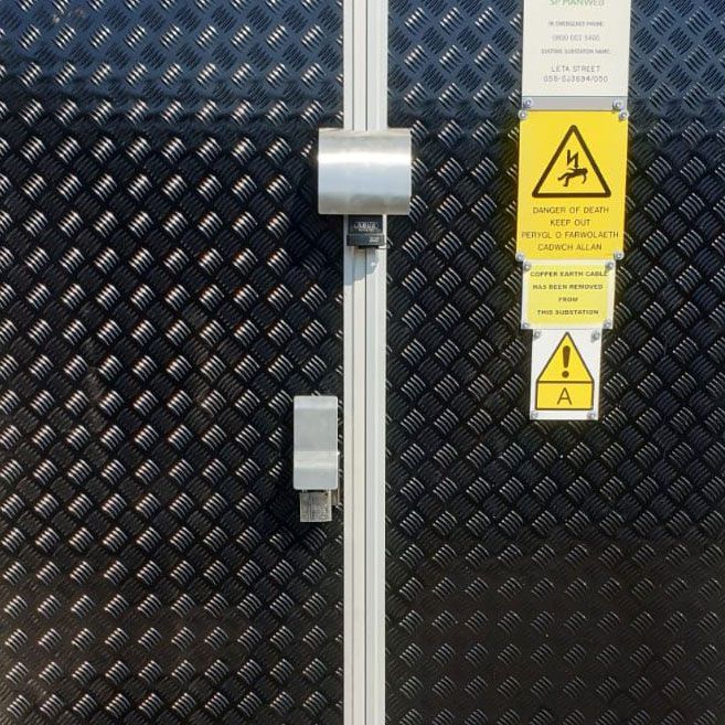 A black door with a yellow warning sign on it
