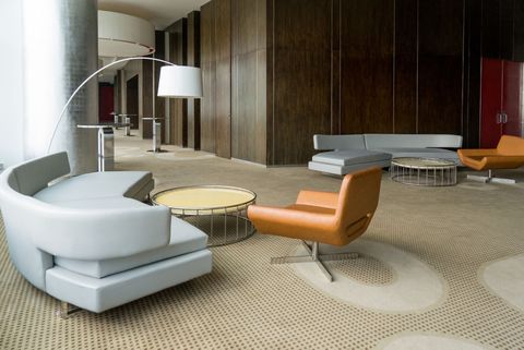 A living room with a couch and chairs and a lamp