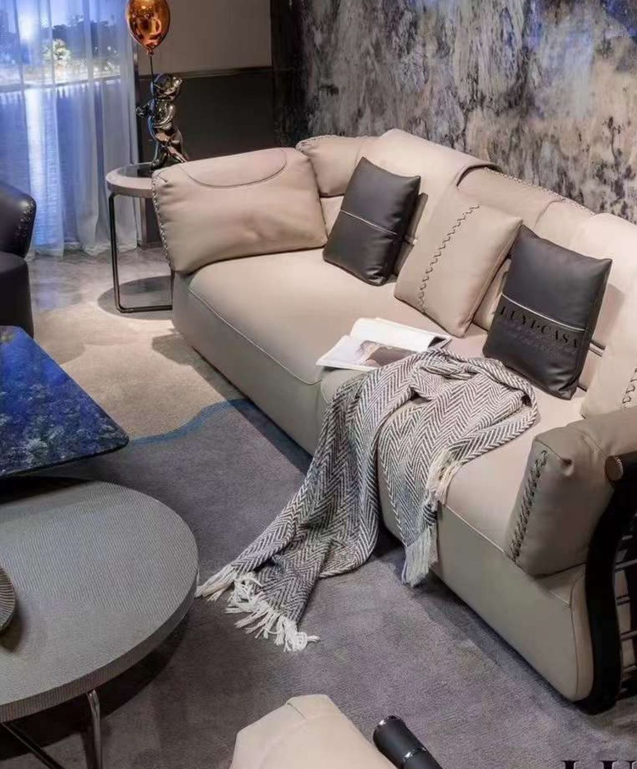 A living room with a red couch , two chairs , and a rug.