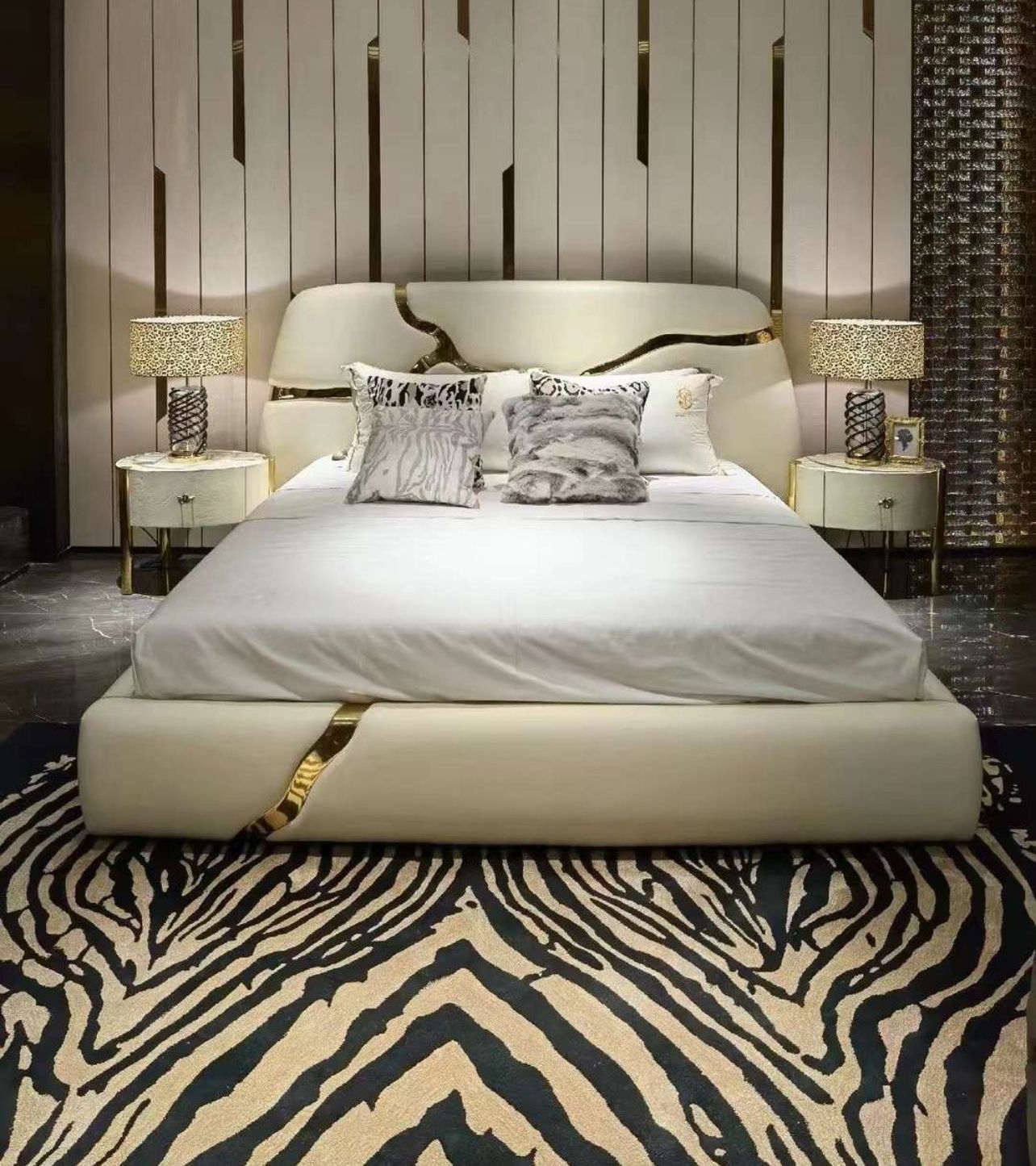 A bedroom with a bed , dresser , nightstand , mirror and rug.